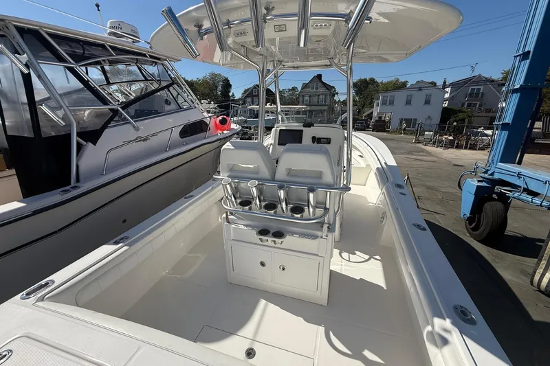  Yacht Photos Pics 2017 Regulator 25 boat interior with seating and console, docked beside another vessel.