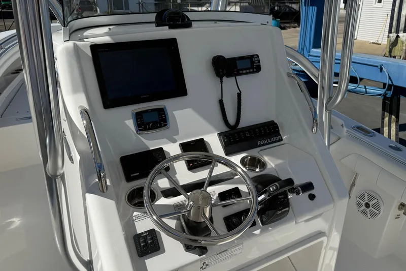  Yacht Photos Pics 2017 Regulator 25 boat console with steering wheel, navigation equipment, and communication devices.