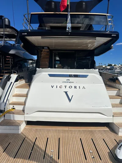  Yacht Photos Pics 2023 Cranchi Settantotto 78 yacht, rear view with "Victoria" nameplate, docked under clear blue sky.