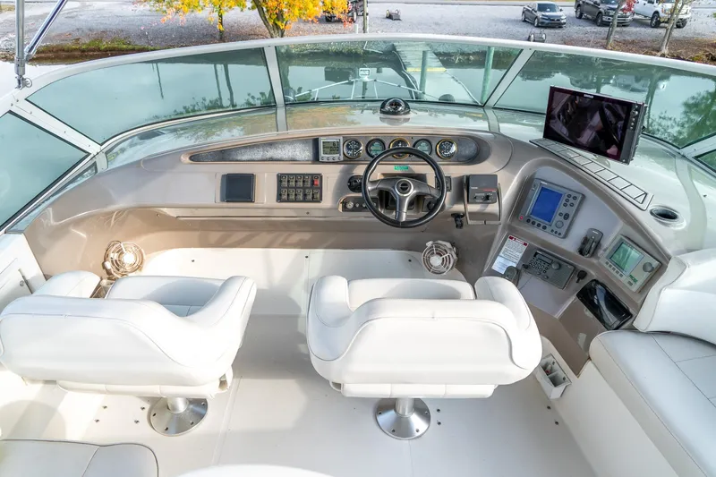  Yacht Photos Pics Pilothouse interior of 2000 Carver 450 Voyager, featuring dual white captain chairs and navigation equipment.