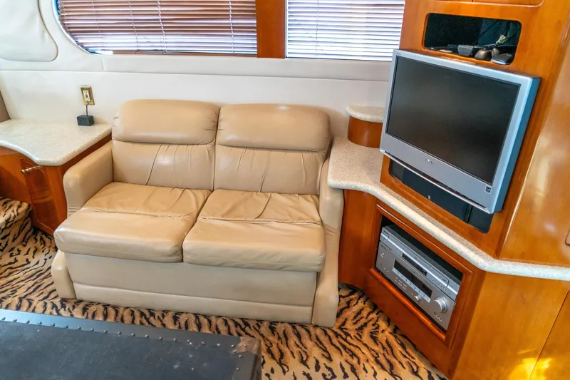  Yacht Photos Pics Interior of 2000 Carver 450 Voyager Pilothouse with beige sofa and entertainment center.