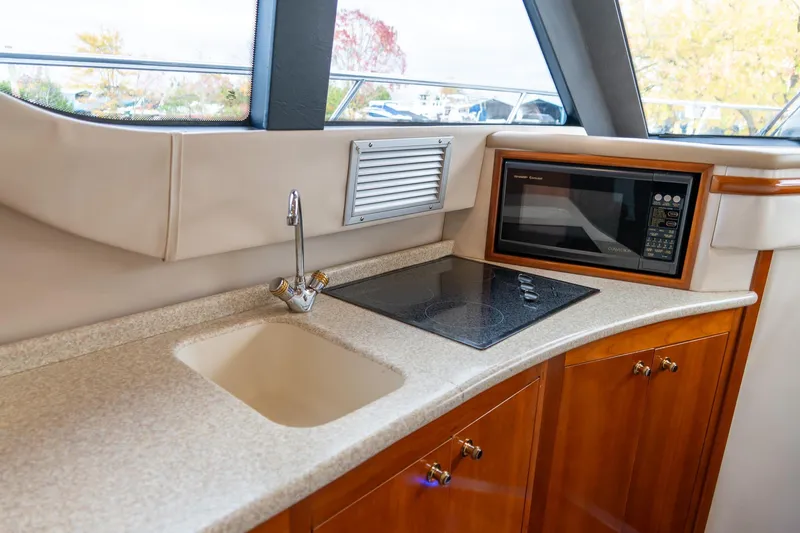  Yacht Photos Pics 2000 Carver 450 Voyager Pilothouse kitchen with sink, stovetop, and microwave.
