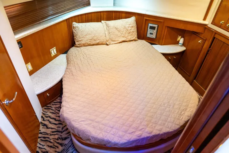  Yacht Photos Pics Cozy bedroom in 2000 Carver 450 Voyager Pilothouse yacht with wood accents and plush bedding.
