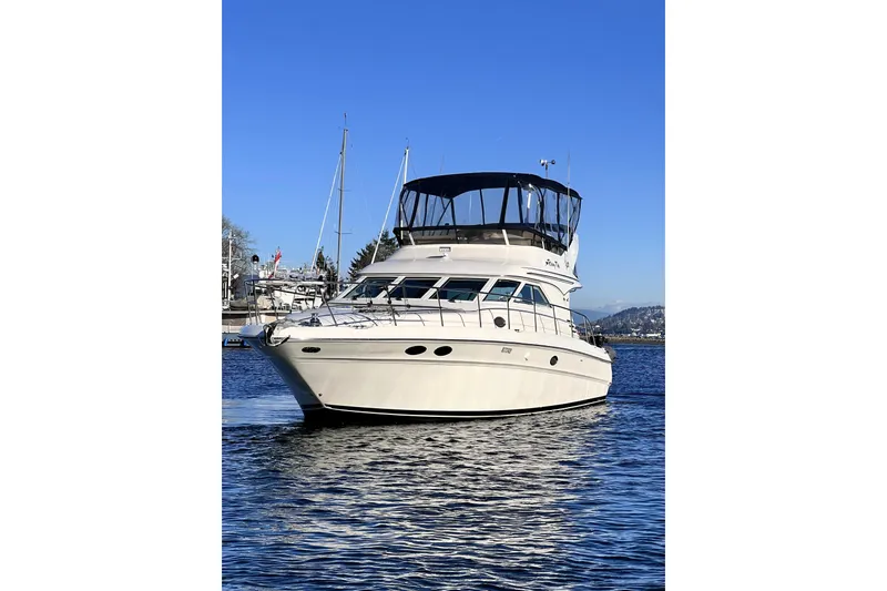 Rising Tide Yacht Photos Pics 1996 Sea Ray 400 Sedan Bridge yacht on calm water under clear blue sky.