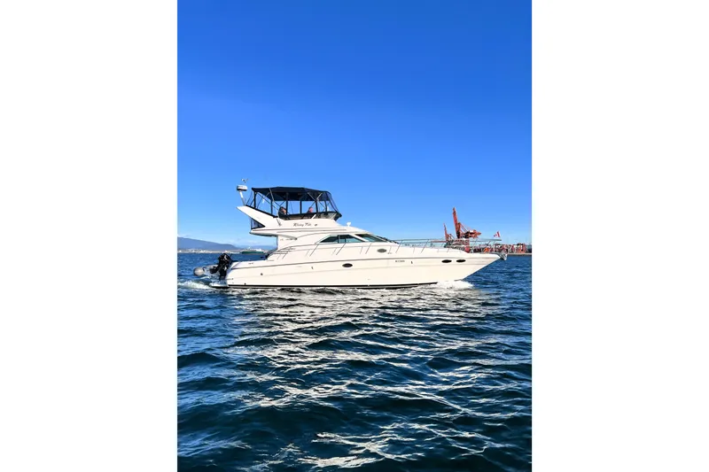 Rising Tide Yacht Photos Pics 1996 Sea Ray 400 Sedan Bridge yacht cruising on open water under clear blue sky.