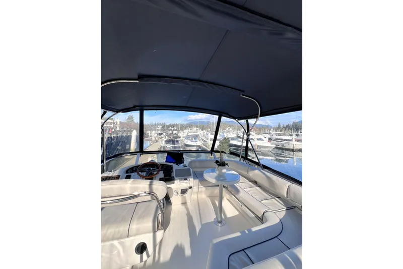Rising Tide Yacht Photos Pics 1996 Sea Ray 400 Sedan Bridge interior with marina view, featuring helm and seating area.