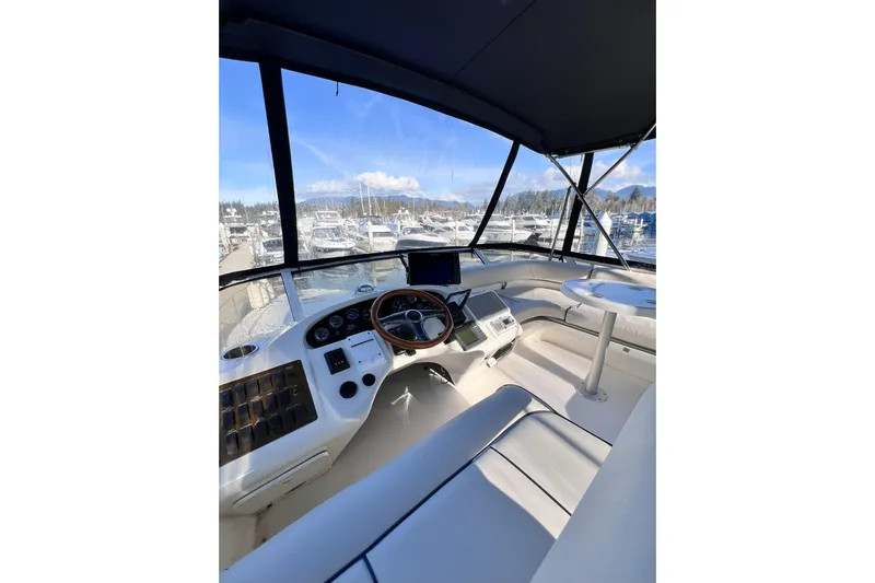 Rising Tide Yacht Photos Pics 1996 Sea Ray 400 Sedan Bridge helm with marina view, featuring modern controls and seating.