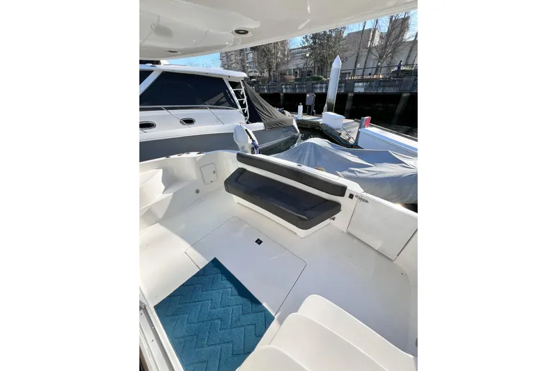 Rising Tide Yacht Photos Pics 1996 Sea Ray 400 Sedan Bridge cockpit with seating and blue mat, docked at marina.