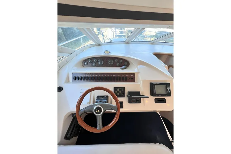 Rising Tide Yacht Photos Pics 1996 Sea Ray 400 Sedan Bridge helm with steering wheel and navigation controls.