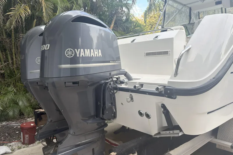  Yacht Photos Pics 2002 Boston Whaler 285 Conquest with twin Yamaha outboard engines, docked near tropical foliage.
