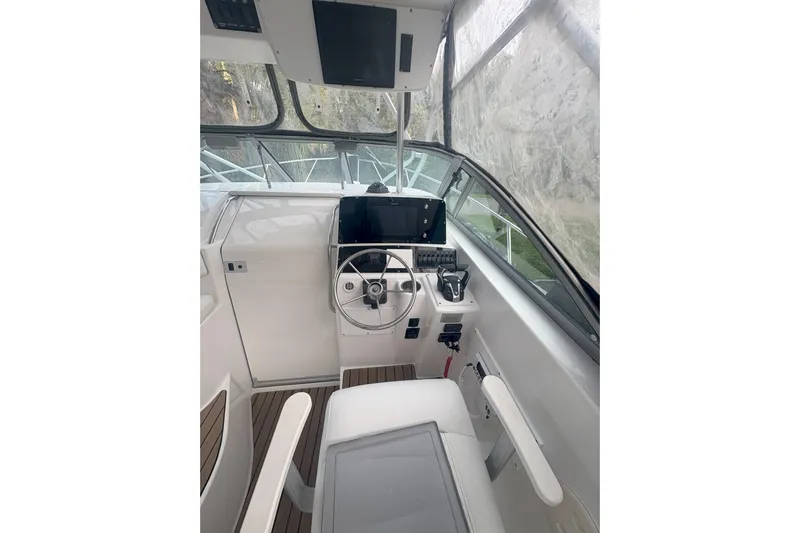  Yacht Photos Pics 2002 Boston Whaler 285 Conquest helm with steering wheel and navigation equipment.