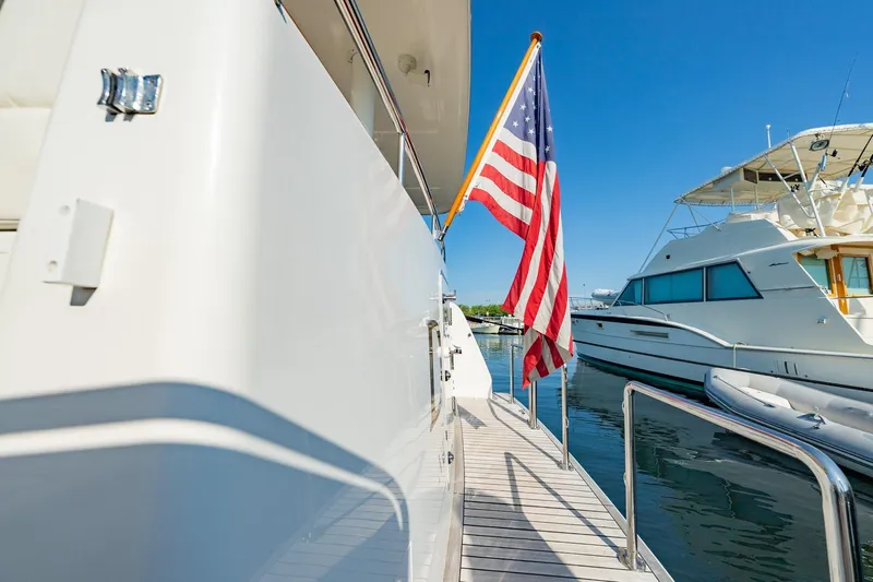 Dash Yacht Photos Pics 2016 Grand Banks 72 Aleutian RP yacht with American flag, docked in marina.