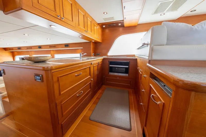Dash Yacht Photos Pics Luxurious kitchen interior of 2016 Grand Banks 72 Aleutian RP yacht with wooden cabinetry.