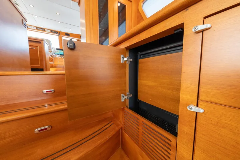 Dash Yacht Photos Pics Interior of 2016 Grand Banks 72 Aleutian RP yacht with open wooden cabinet.