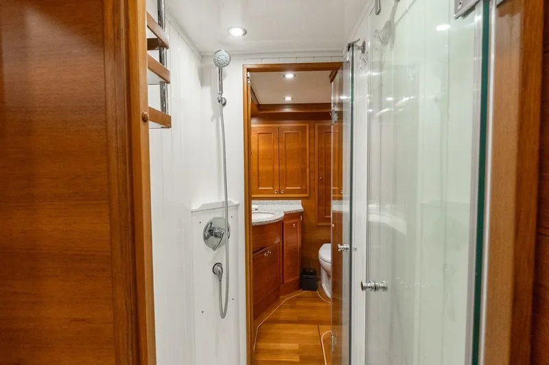 Dash Yacht Photos Pics Luxurious bathroom in 2016 Grand Banks 72 Aleutian RP yacht with wooden cabinetry and modern fixtures.