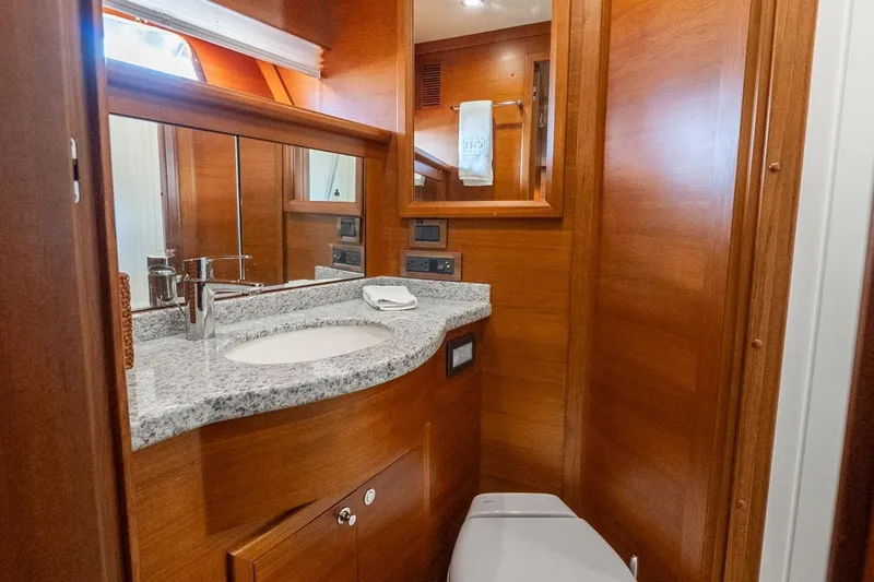 Dash Yacht Photos Pics Luxurious bathroom in 2016 Grand Banks 72 Aleutian RP yacht with wood finish and granite countertop.