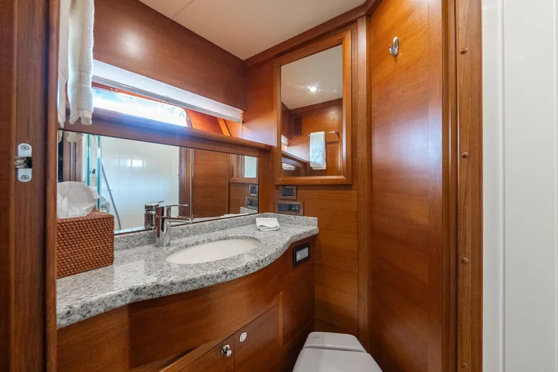 Dash Yacht Photos Pics Luxurious bathroom in 2016 Grand Banks 72 Aleutian RP yacht with wood finish and granite countertop.