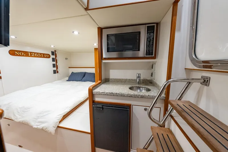 Dash Yacht Photos Pics Interior of 2016 Grand Banks 72 Aleutian RP with bed, kitchenette, and stairs.