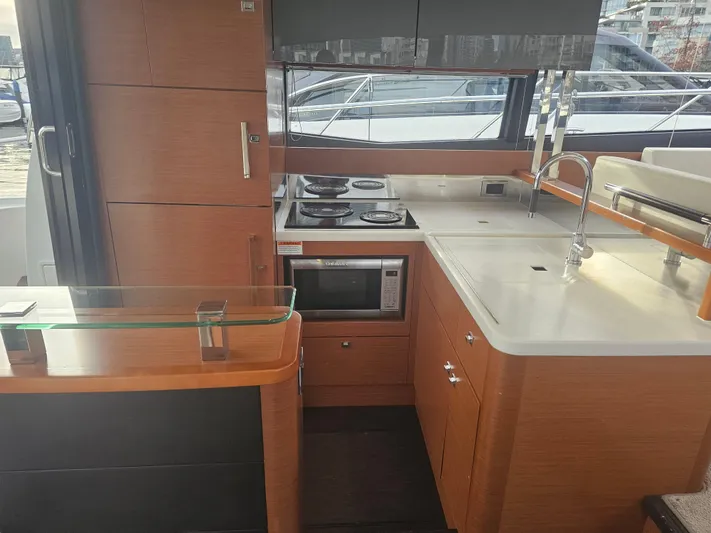Yes Yacht Photos Pics Modern kitchen interior of 2016 Prestige 500 S yacht with stove, microwave, and sink.