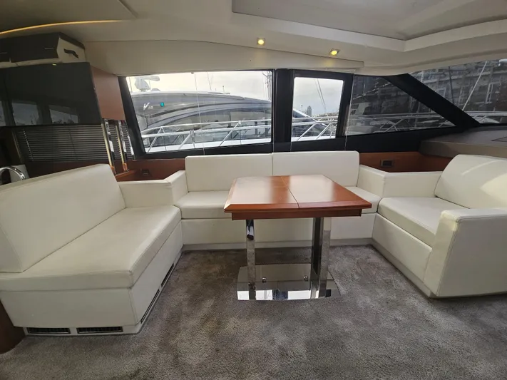 Yes Yacht Photos Pics Luxurious interior of a 2016 Prestige 500 S yacht with white seating and wooden table.