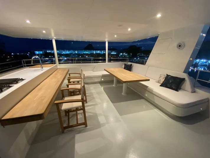  Yacht Photos Pics Luxurious 2027 Inace Explora 90 yacht deck with seating and dining area at night.