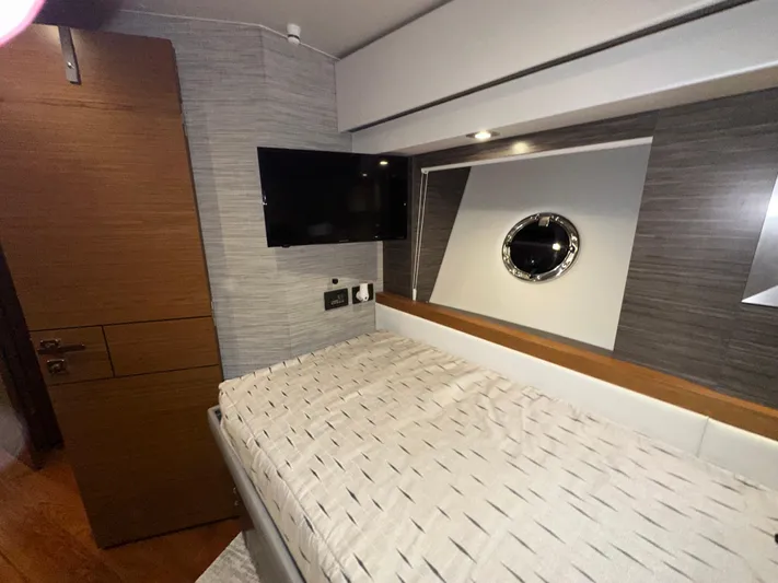 Sapphire Yacht Photos Pics 2020 Tiara Yachts F53 Flybridge cabin interior with bed, TV, and porthole window.