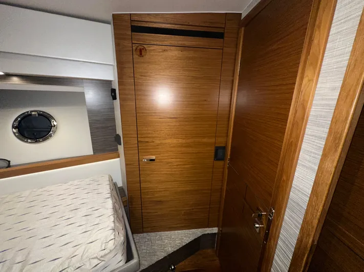 Sapphire Yacht Photos Pics 2020 Tiara Yachts F53 Flybridge cabin interior with wooden doors and bed.