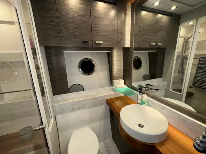 Sapphire Yacht Photos Pics Luxurious bathroom in 2020 Tiara Yachts F53 Flybridge with modern fixtures and wood accents.