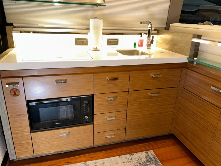 Sapphire Yacht Photos Pics Modern kitchen area in 2020 Tiara Yachts F53 Flybridge with wood cabinetry and appliances.