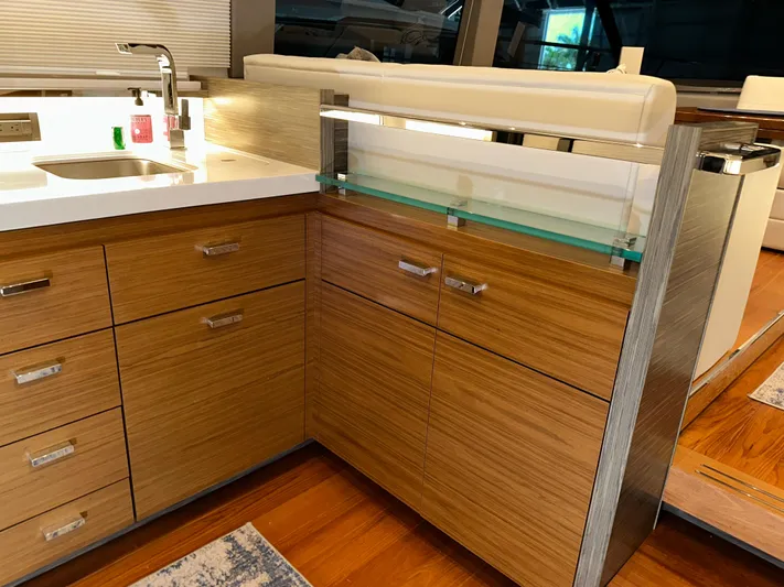 Sapphire Yacht Photos Pics Modern kitchen interior on 2020 Tiara Yachts F53 Flybridge, featuring sleek wood cabinetry and countertops.