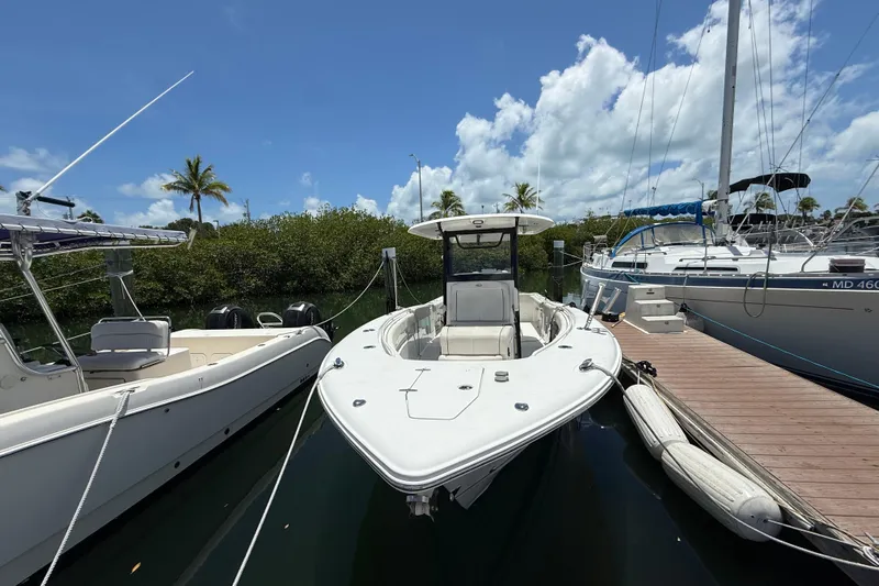 Afterthought Yacht Photos Pics 2022 Sea Hunt Gamefish 30 Coffin Box boat docked, surrounded by other boats, under a clear sky.
