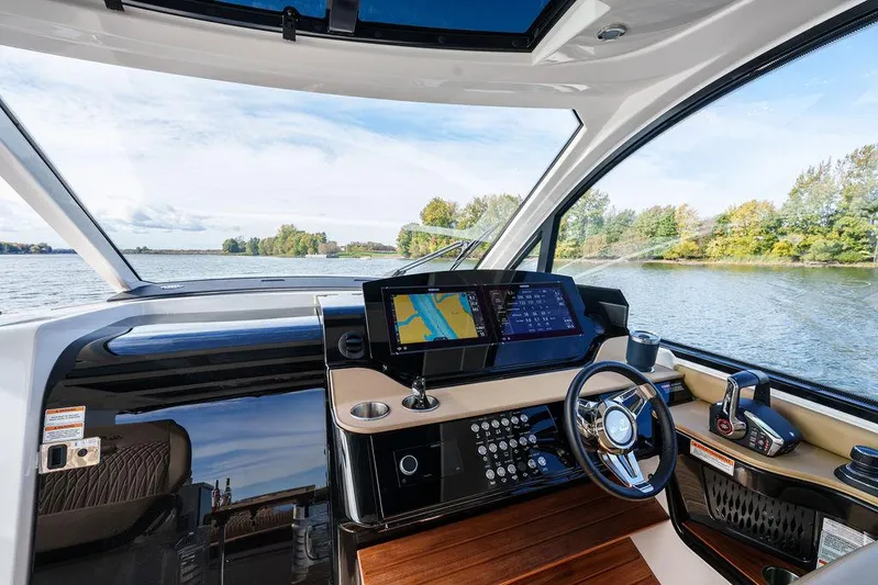  Yacht Photos Pics 2023 Sea Ray Sundancer 370 Outboard helm with modern navigation system on a scenic lake.
