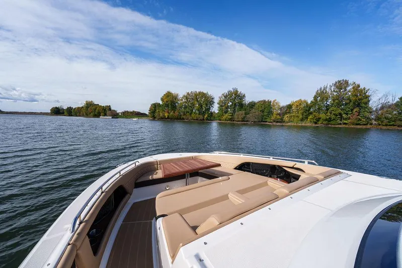  Yacht Photos Pics 2023 Sea Ray Sundancer 370 Outboard cruising on a serene lake under a clear blue sky.