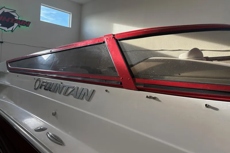  Yacht Photos Pics 2006 Fountain 42 Lightning boat with red trim and logo in a sunlit garage.