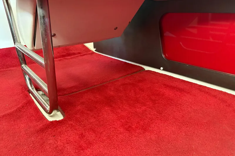  Yacht Photos Pics Red carpet interior of a 2006 Fountain 42 Lightning boat with metal railing.