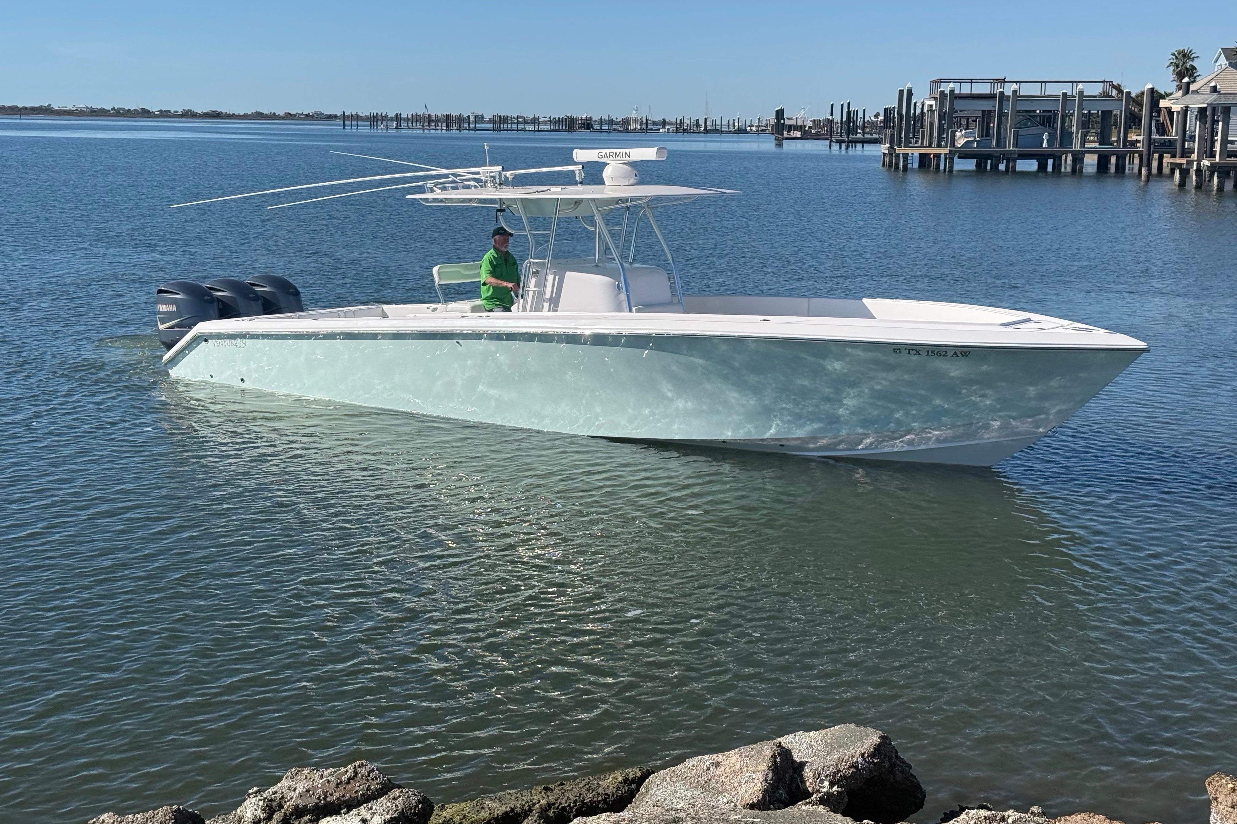 2009 Venture 39 Open boat on calm water near a dock.
