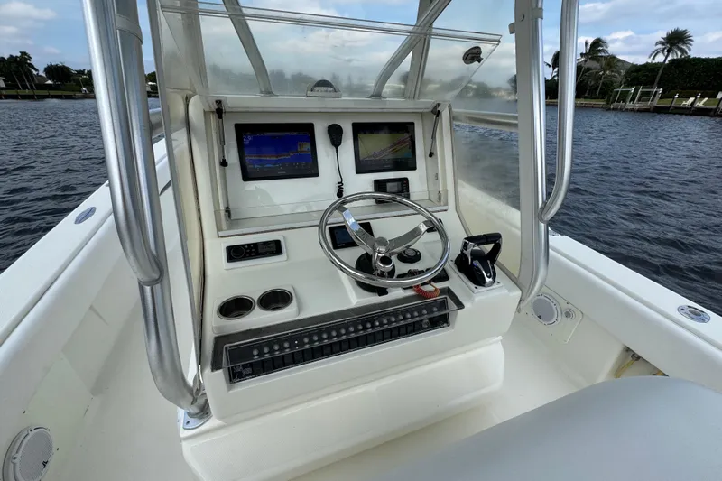  Yacht Photos Pics 2013 SeaVee 320B boat console with steering wheel, navigation screens, and controls on the water.