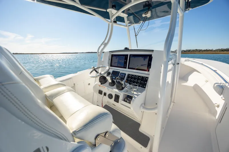Seachosis Yacht Photos Pics 2014 Southport 29TE boat interior with dual screens and steering wheel on calm water.