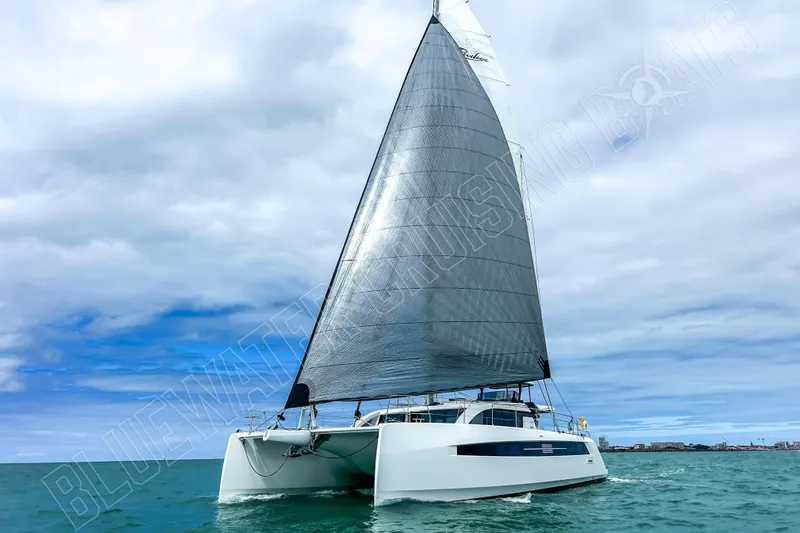 Fun Pass Yacht Photos Pics Sailing catamaran Privilege 580, 2025 model, cruising on open water under cloudy skies.