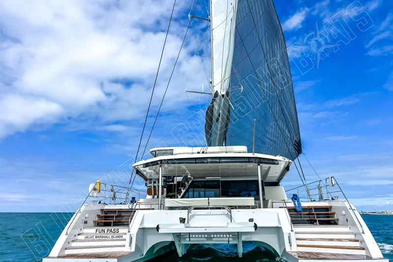 Fun Pass Yacht Photos Pics Luxury Privilege 580 catamaran sailing on open sea under clear blue skies, 2025 model.