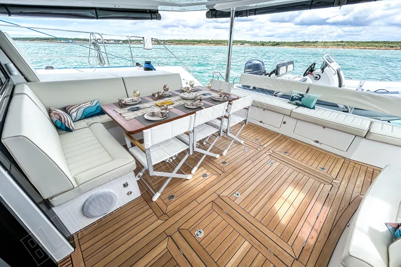 Fun Pass Yacht Photos Pics Luxurious 2025 Privilege 580 yacht deck with elegant dining setup and scenic ocean view.