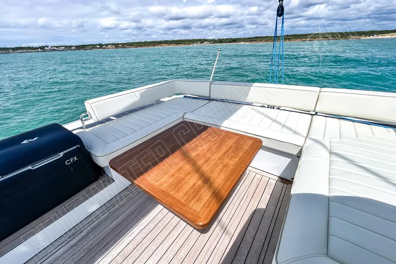 Fun Pass Yacht Photos Pics Luxurious Privilege 580 yacht deck with seating and wooden table, 2025 model.