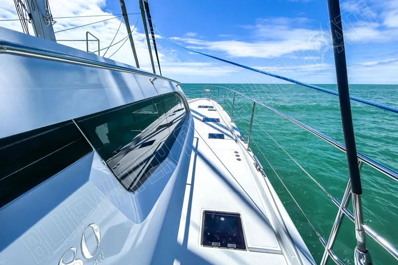 Fun Pass Yacht Photos Pics Sleek Privilege 580 yacht sailing on turquoise sea under clear blue sky, 2025 model.