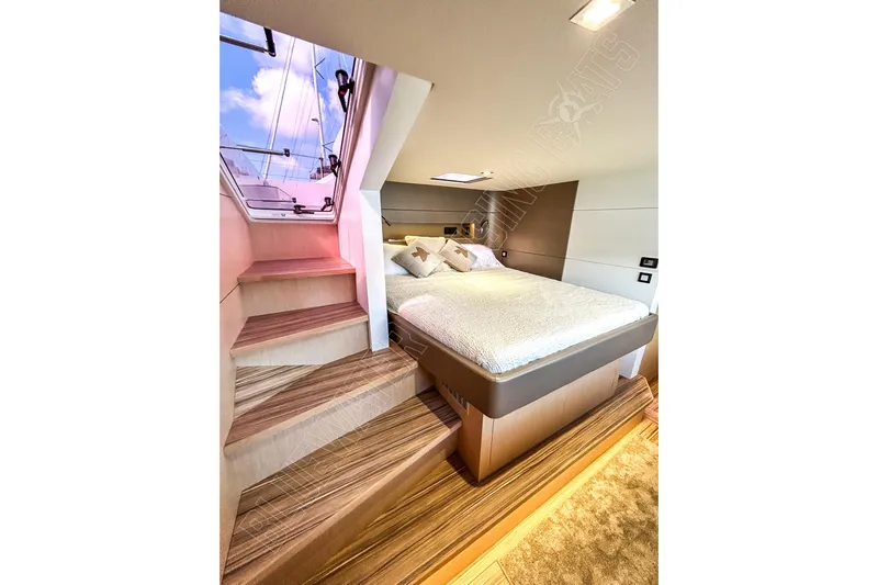 Fun Pass Yacht Photos Pics Luxurious cabin interior of 2025 Privilege 580 yacht with cozy bed and wooden steps.