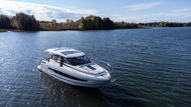  Yacht Photos Pics 2021 Jeanneau NC 37 boat cruising on a serene lake under a clear sky.
