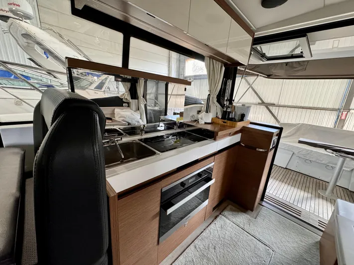  Yacht Photos Pics Interior of 2021 Jeanneau NC 37 yacht, featuring modern kitchen and seating area.