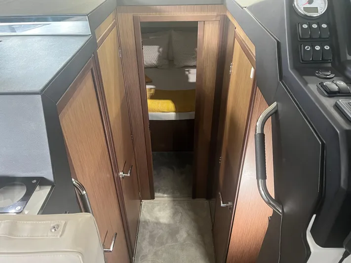  Yacht Photos Pics Interior view of 2021 Jeanneau NC 37 cabin with wood paneling and cozy bed.