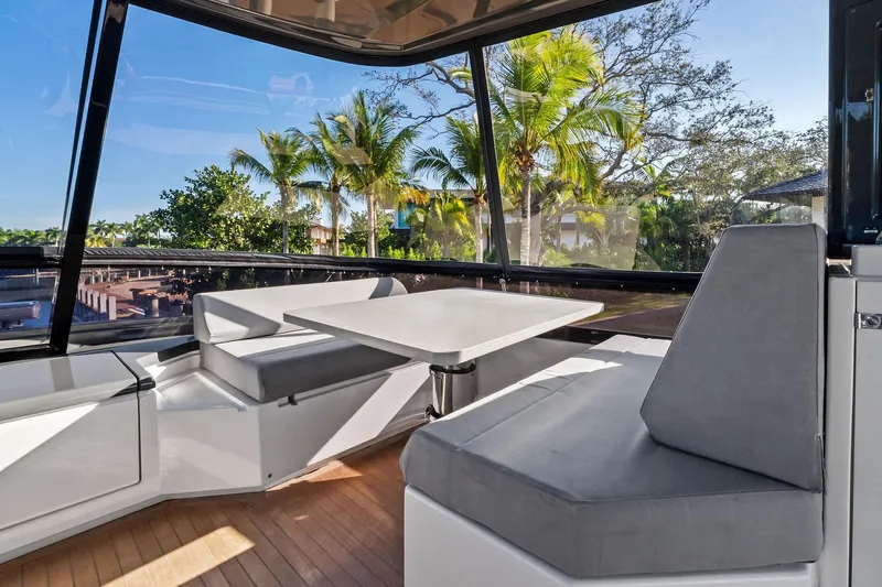 Sunsation Yacht Photos Pics Luxurious 2019 Ferretti Yachts 780 interior with seating and table, surrounded by tropical scenery.