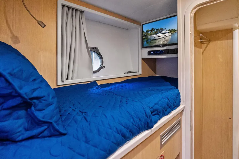 Sunsation Yacht Photos Pics Cozy cabin interior of 2019 Ferretti Yachts 780 with blue bedding and TV.