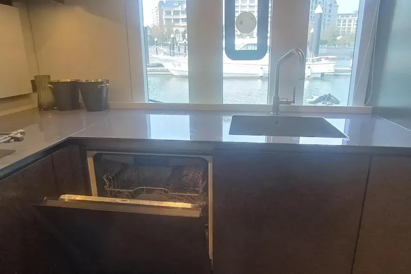  Yacht Photos Pics Modern kitchen on 2021 Sunreef 80 Power yacht with open dishwasher and marina view.